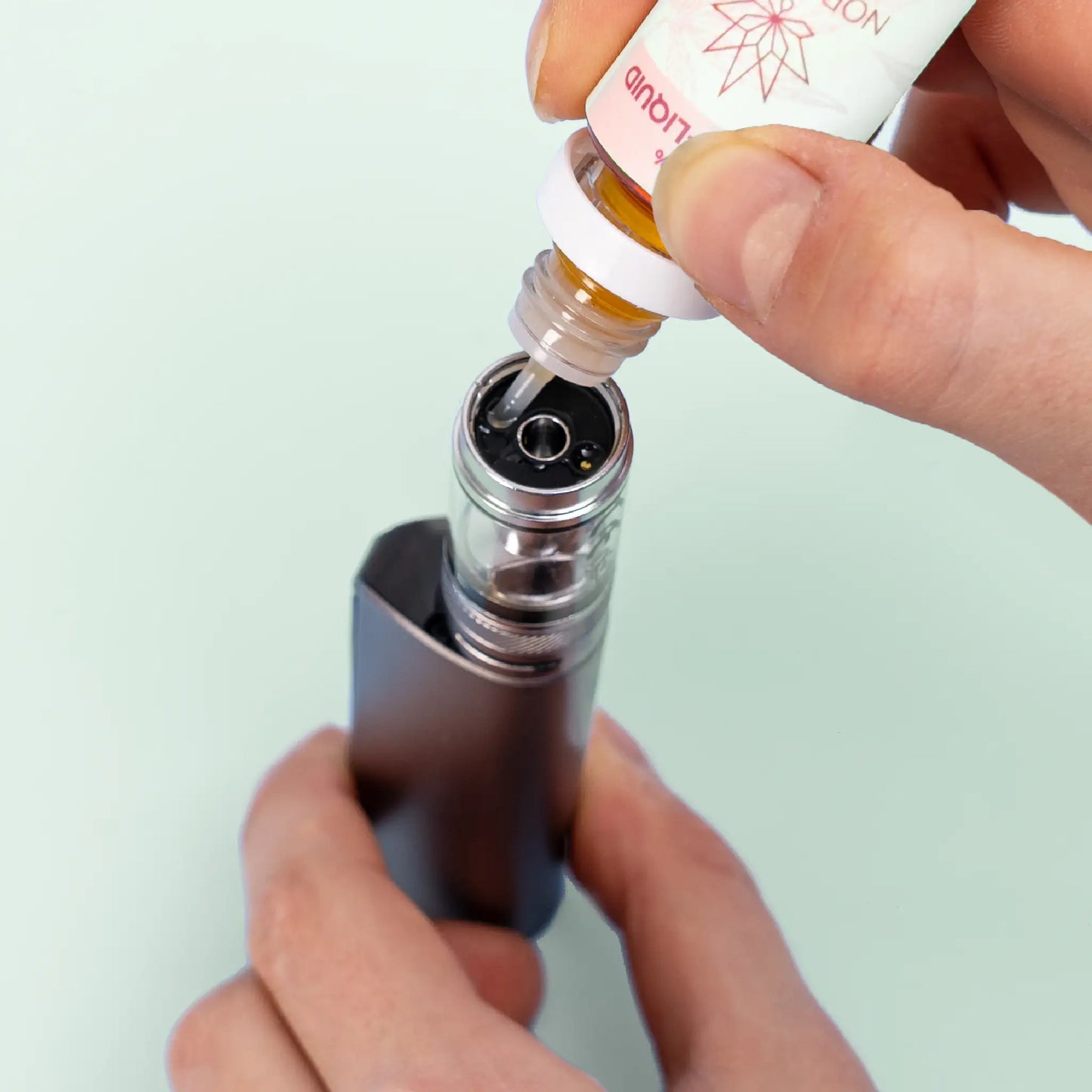 refilling an E-Cigarette with watermelon flavoured CBD E-Liquid from Nordic Oil