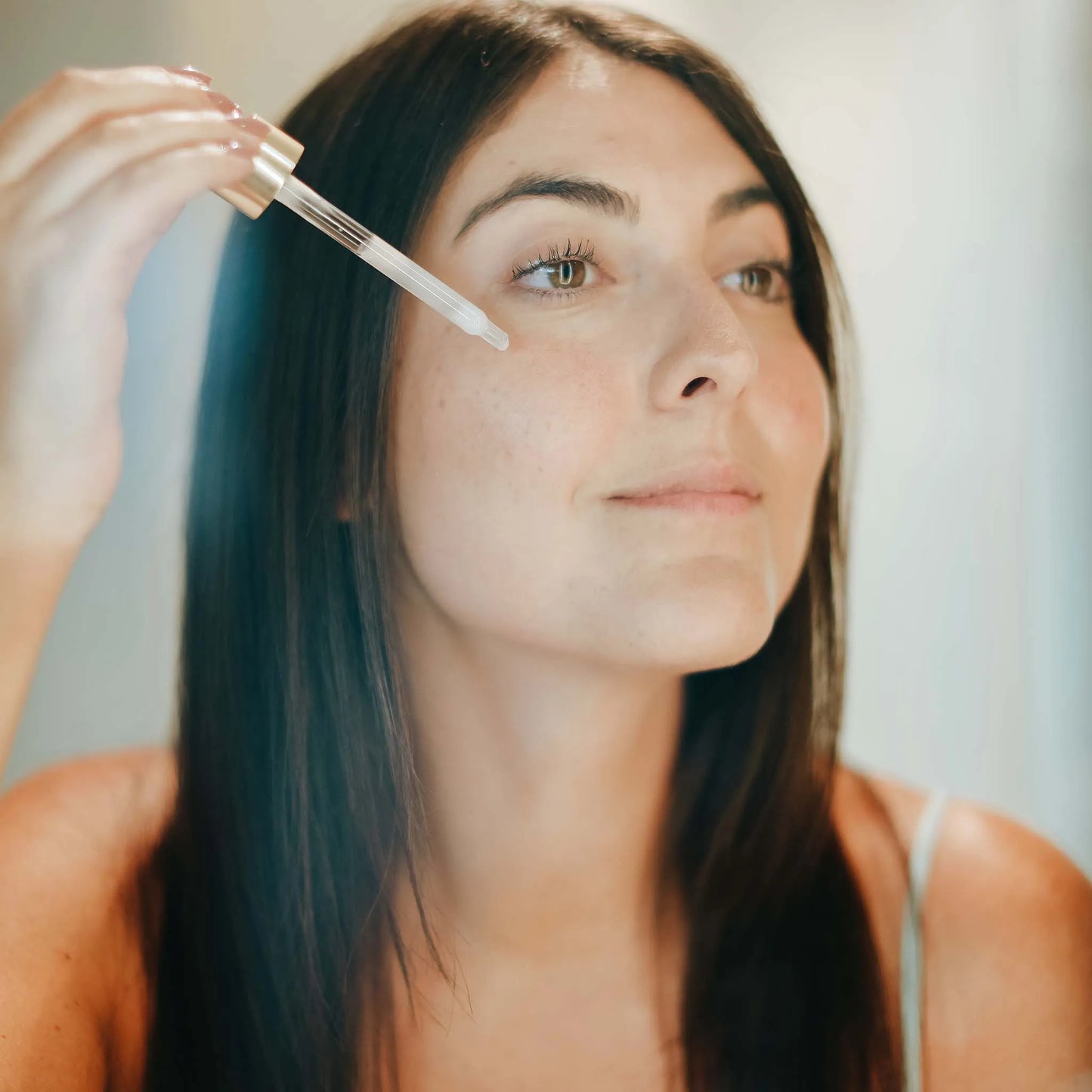 a woman applies the product on her face
