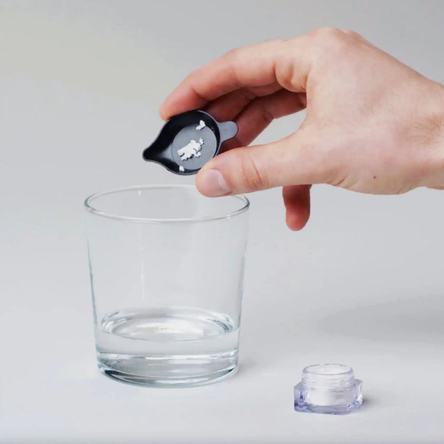 The crystals are put into a glass with a measuring cup.