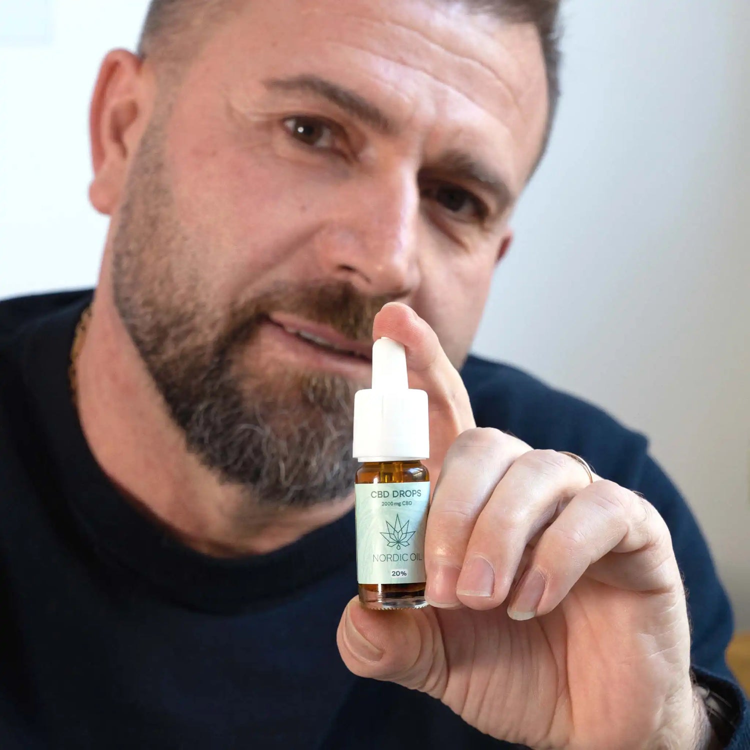 a man holds the cbd oil 