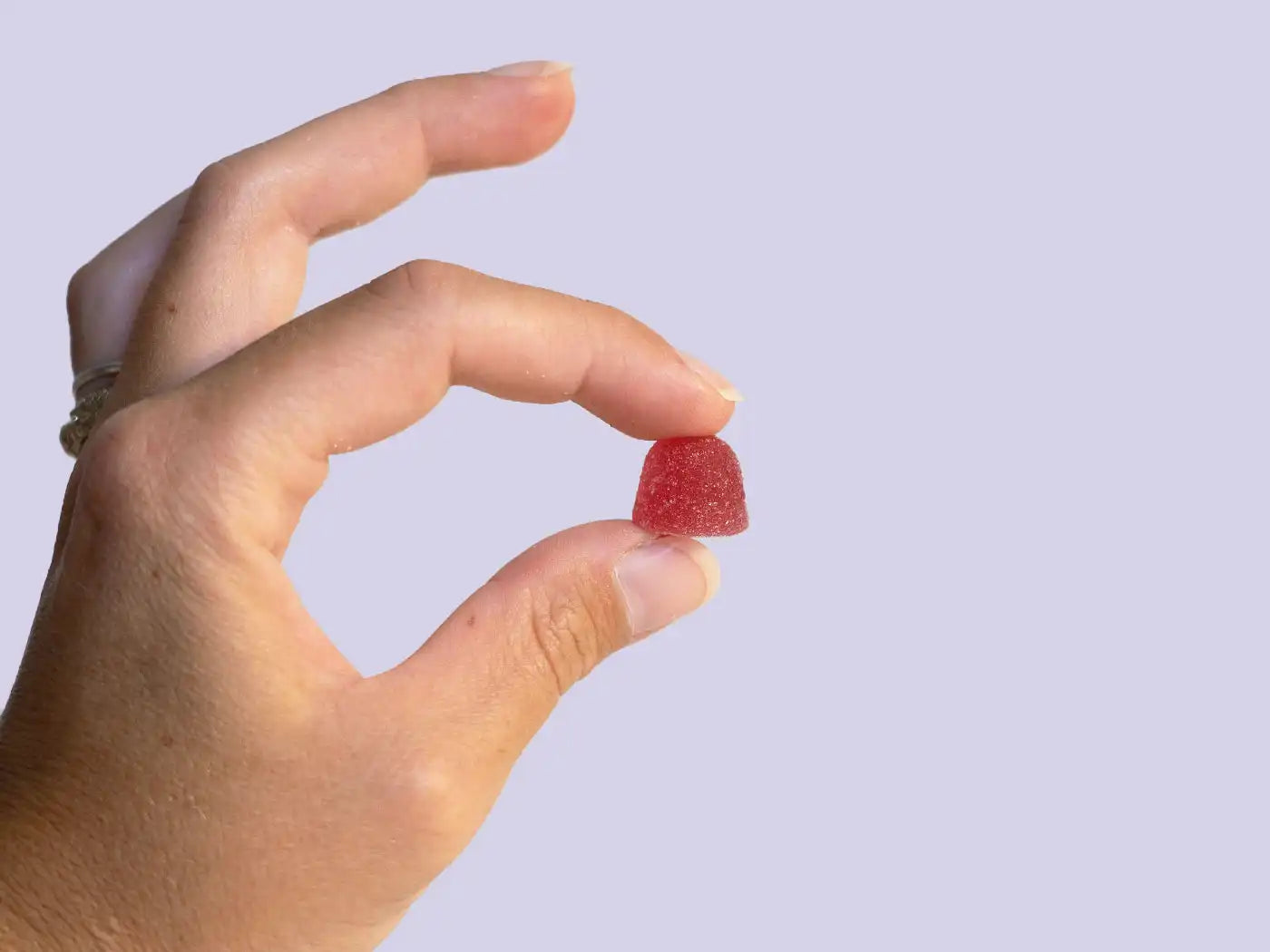 A hand holding a strong CBD gummy